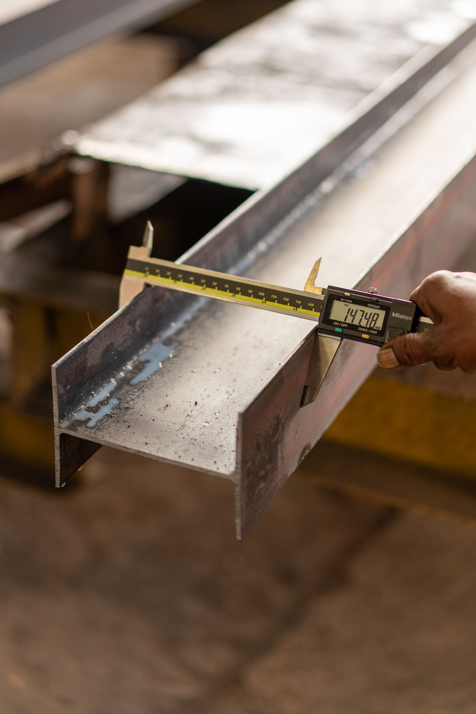 Digital caliper checking a metal section in a workshop