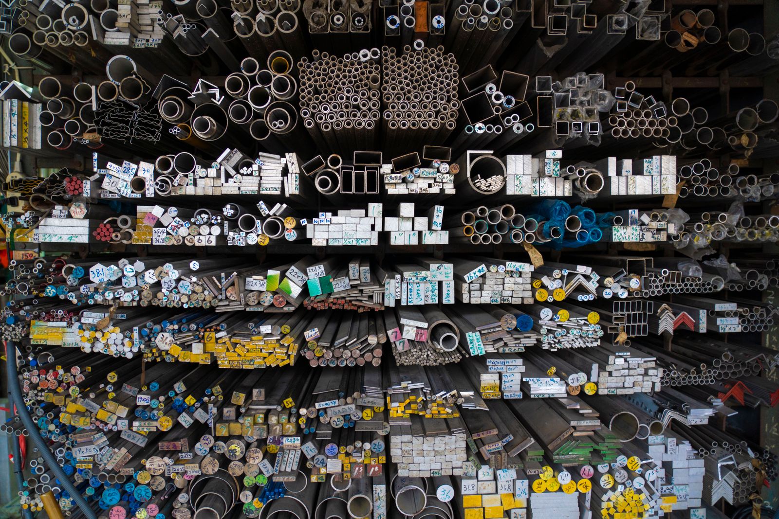 Assorted metal shapes and rods organized in warehouse racks
